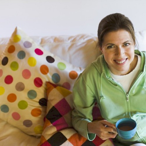 Young woman relaxing with a cup of coffee on a sofa