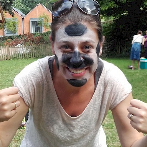 Woman with face painted and thumbs up