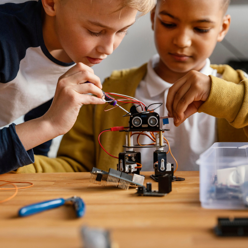 Two young boys building a robot