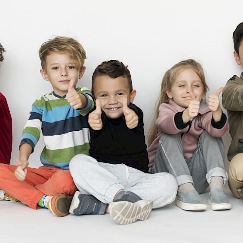 A group of young multi ethnic children with their thumbs up