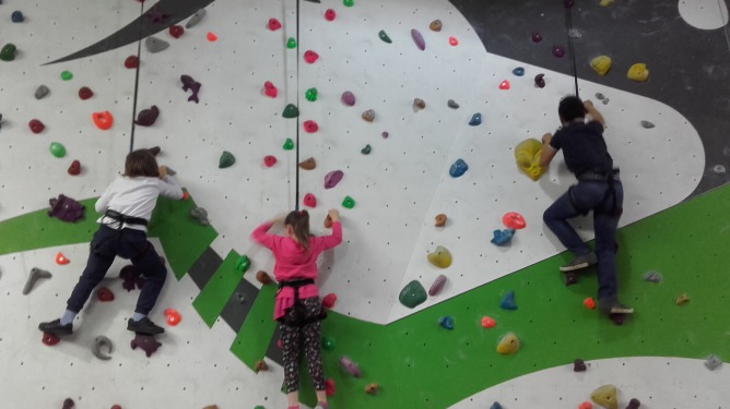 young adopted children climbing rock play wall